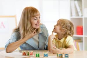 Während der Frankini-Therapie für Kinder im Alter von 3 bis 6 Jahren führt eine Therapeutin Sprechübungen mit einem Kleinkind durch