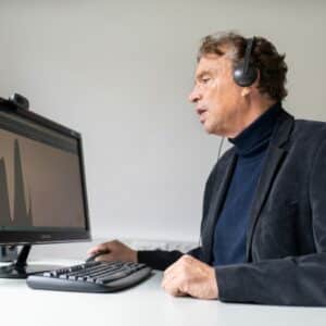 Dr. Alexander Wolff von Gudenberg mit Headset vor dem Computer sitzend beim Üben mit Flunatic
